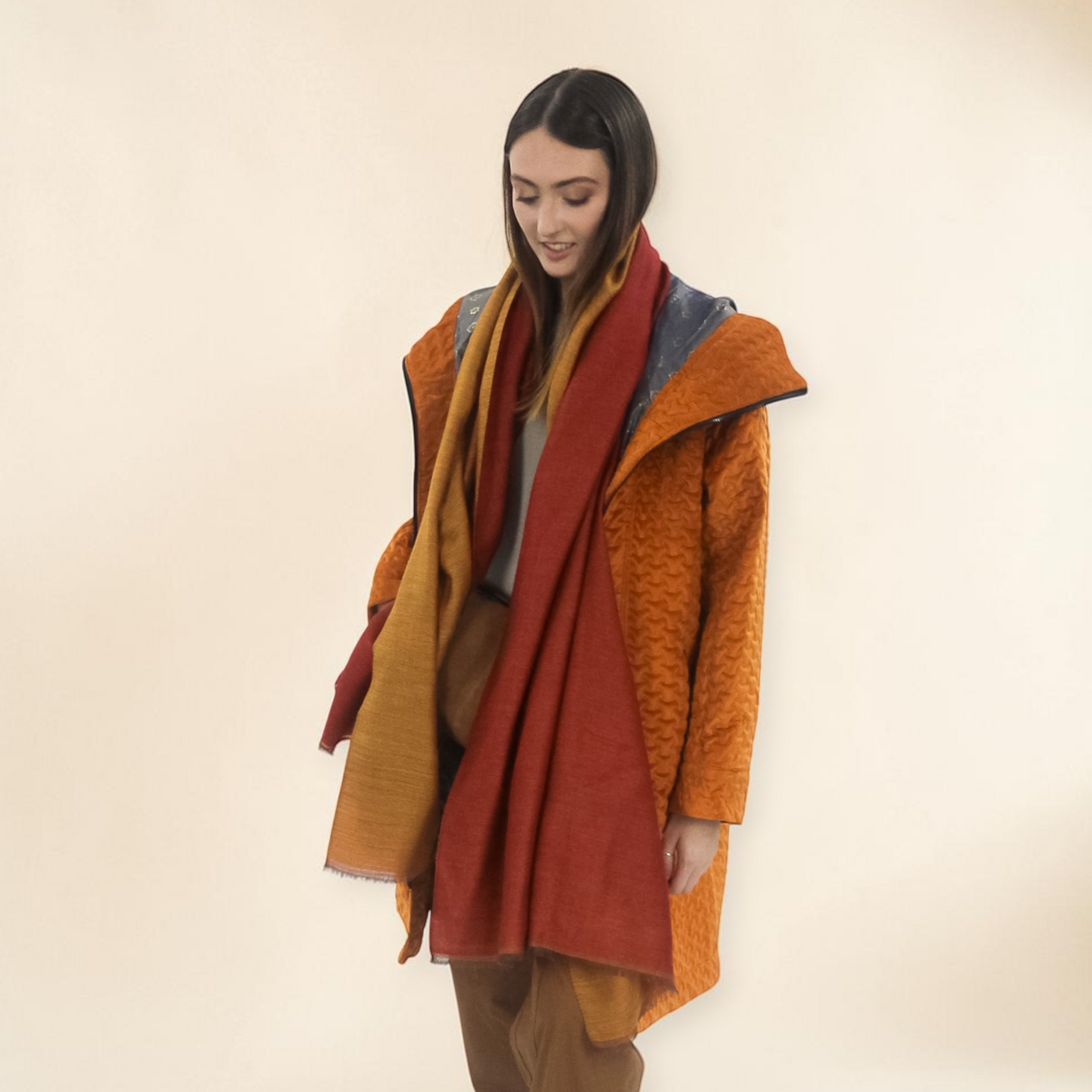 Woman wearing a colorful coat with a neutral background